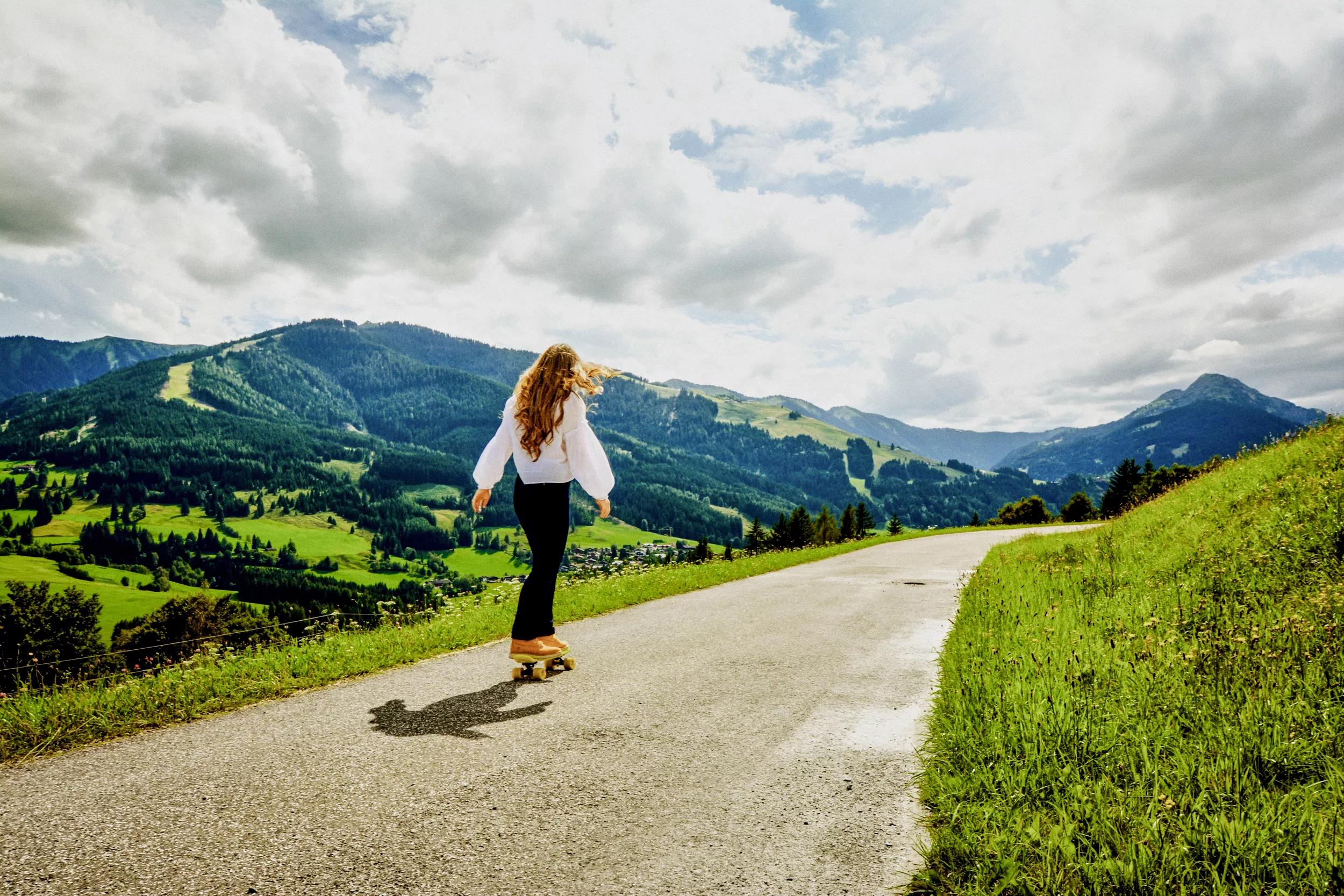 WOMAN STANDING ON ROAD AGAINST SKY